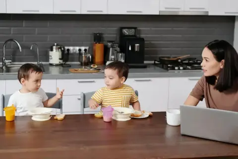 Mama słucha, jak jej dzieci rozmawiają, zastanawiając się, w jakim wieku dziecko zaczyna mówić.