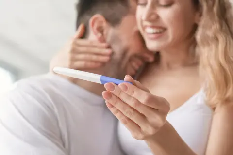 Szczęśliwa para trzyma test ciążowy. Czy jestem w ciąży? Radość i nadzieja w ich oczach.