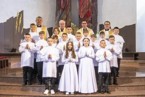 Dzieci w bieli, gotowe na komunię. Zastanawiasz się, ile trwa komunia? To ważny dzień dla tych młodych ludzi.