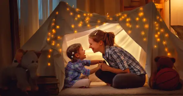 Mama i córka w namiocie z lampek, śpiewają piosenki o mamie.