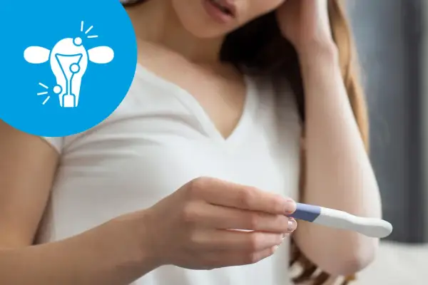 Kobieta z niepokojem patrzy na test ciążowy. Ikona symbolizuje problemy z płodnością, takie jak endometrioza a ciąża.